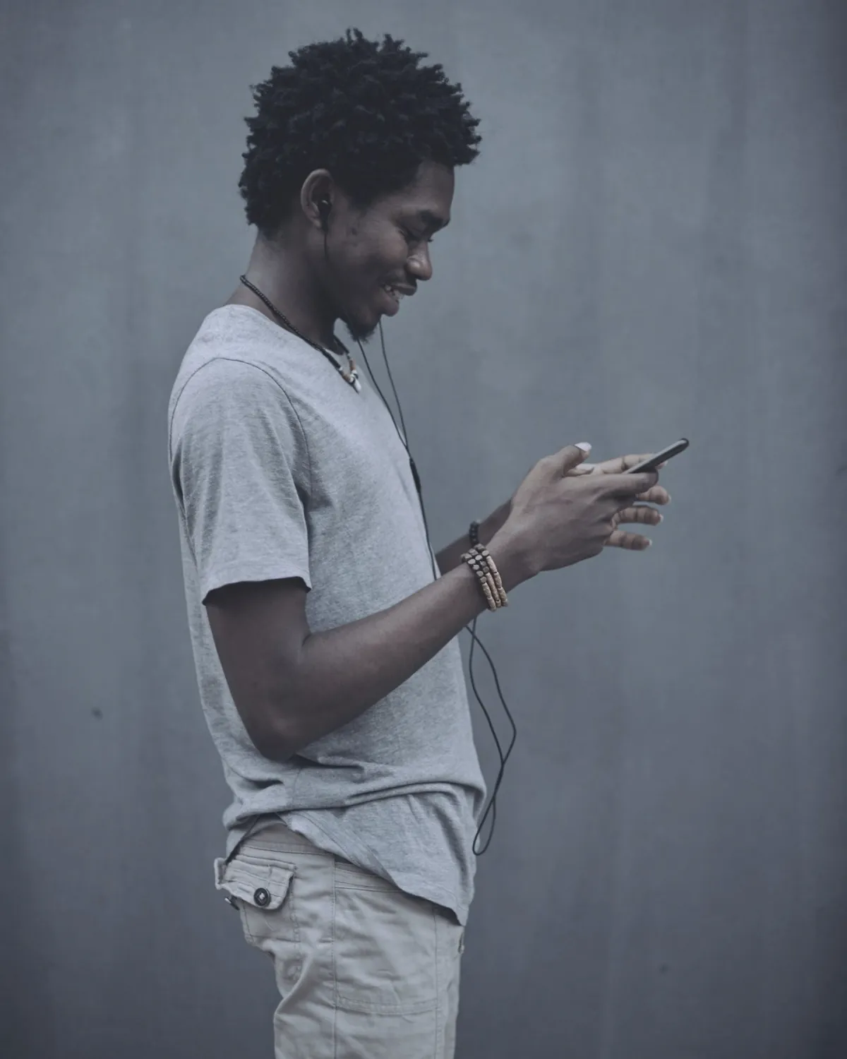 A person standing, looking at their phone.